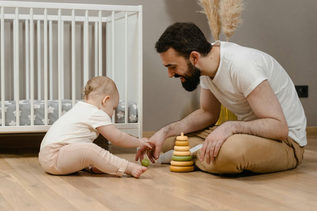 A happy man playing with a baby | Source: Pexels