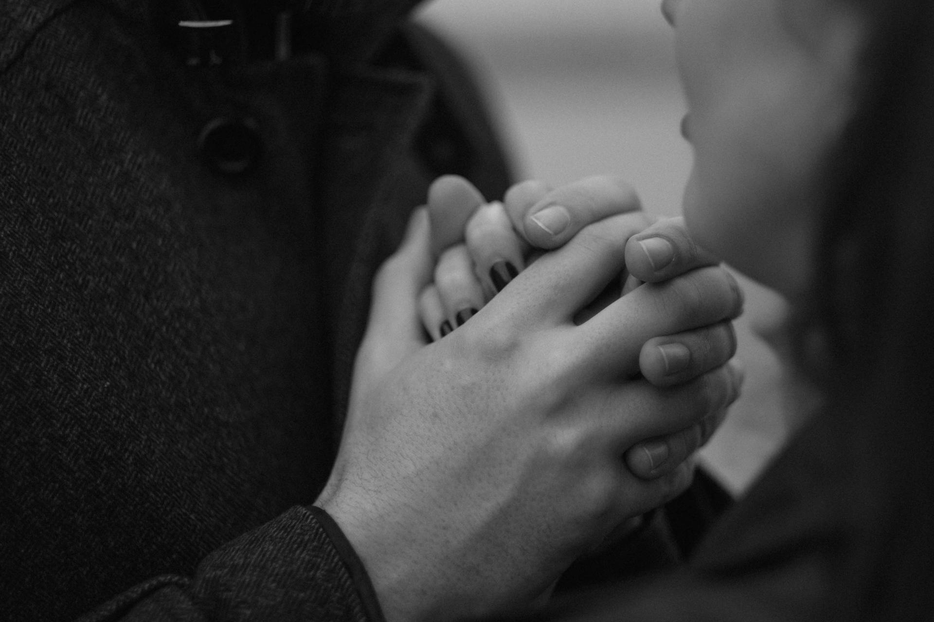 Grayscale shot of a couple holding hands | Source: Pexels
