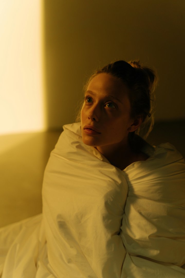 A sad woman sitting in bed while plotting | Source: Pexels