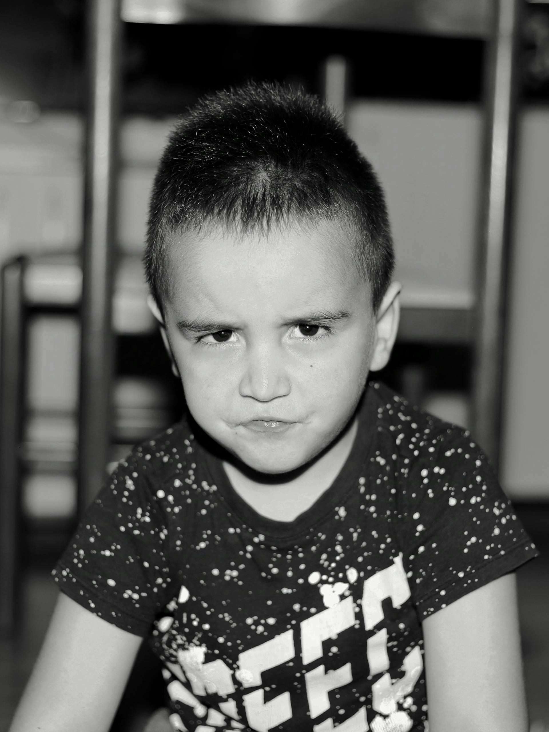 Grayscale photo of a frowning young boy | Source: Pexels