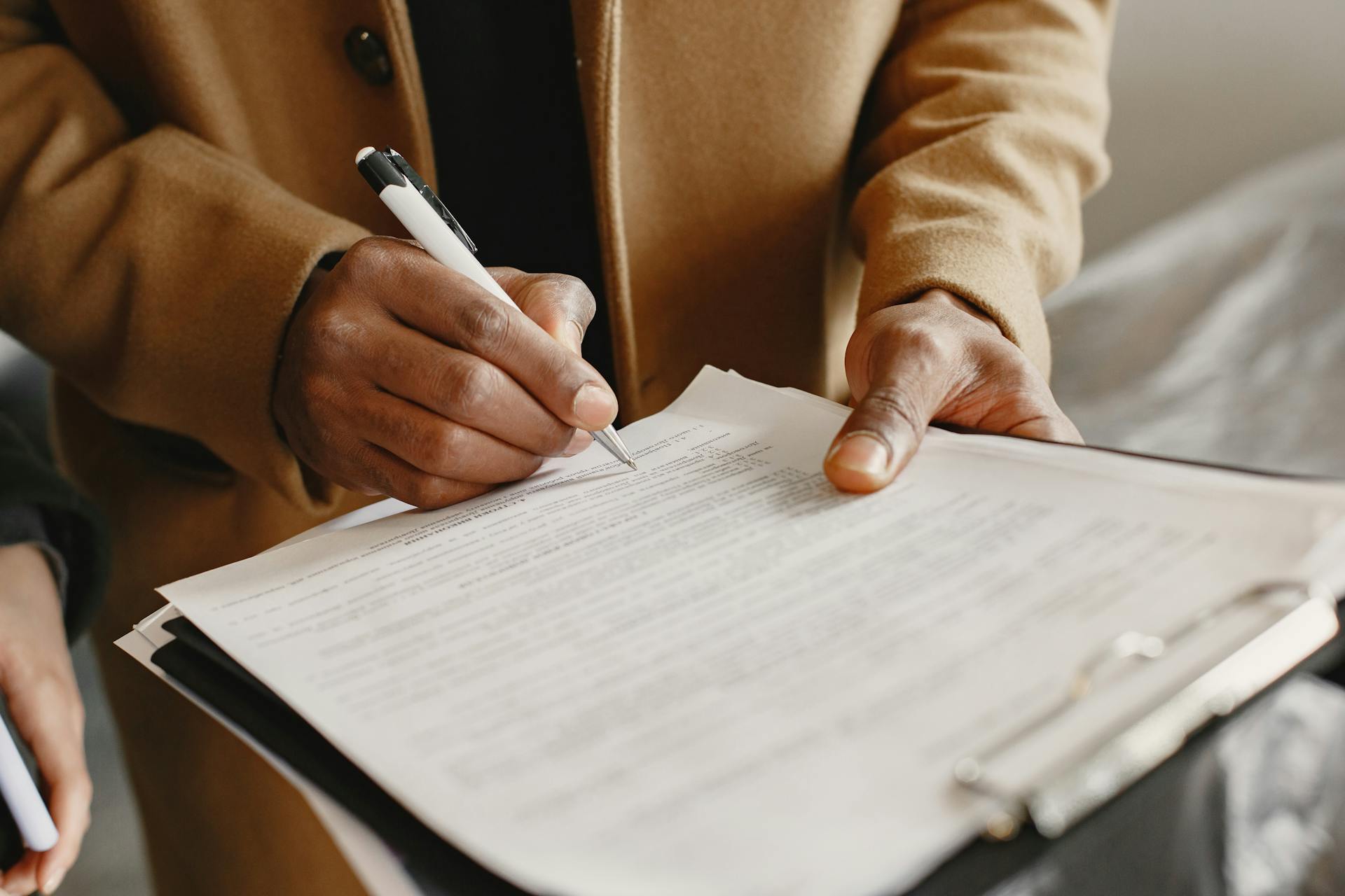 A man writing on a paper with a pen | Source: Pexels