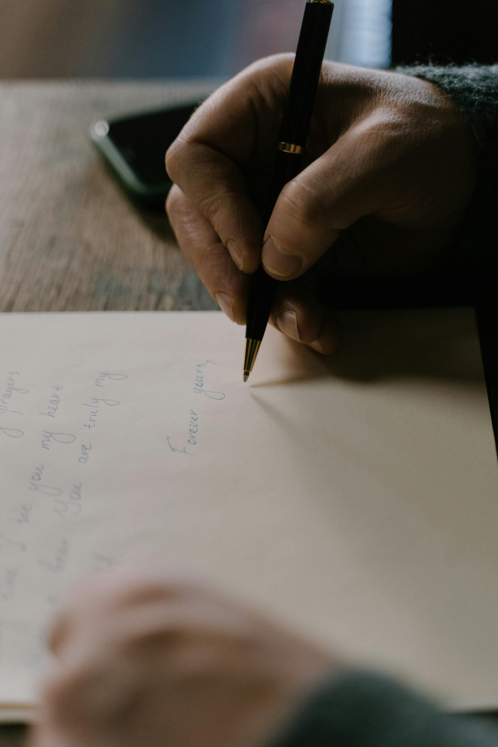 Close-up shot of a man writing a letter | Source: Pexels