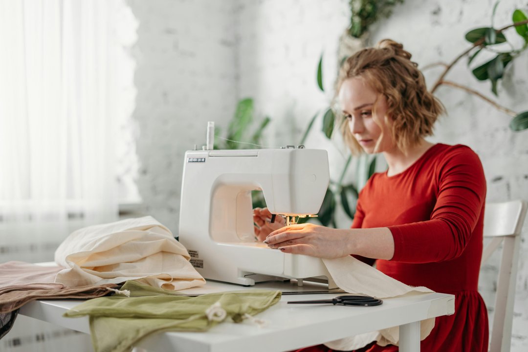 A woman sewing with a machine | Source: Pexels