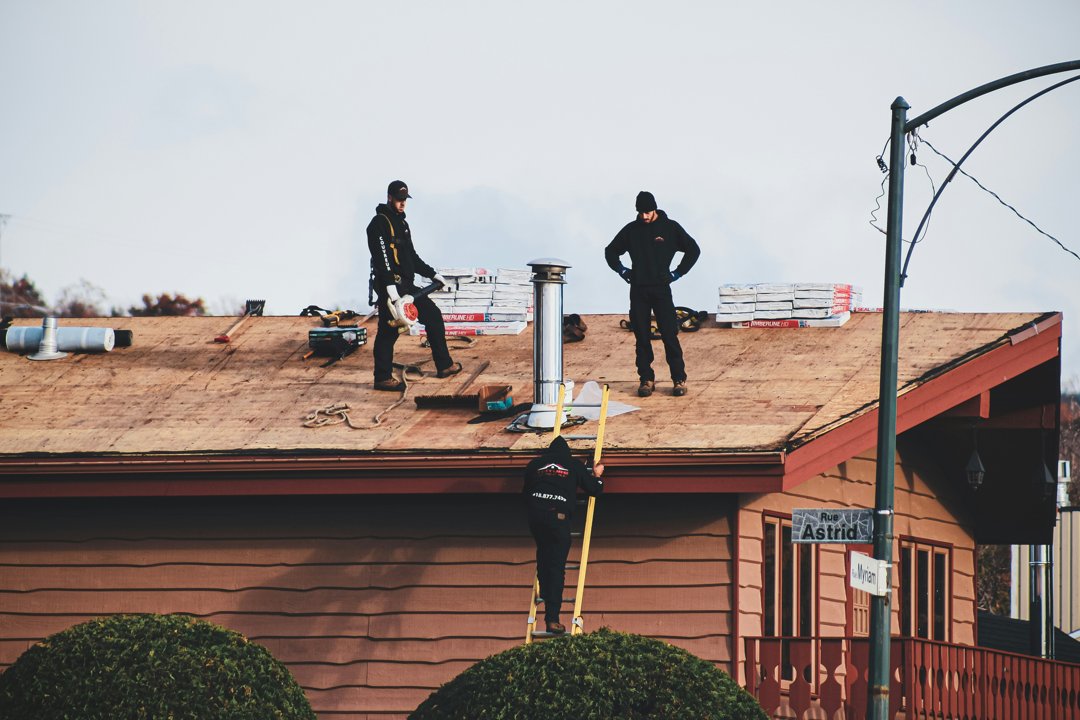 Men standing on top  of a roof | Source: Unsplash