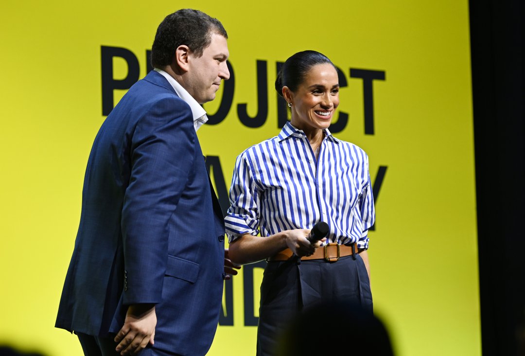 Phil Schermer and Meghan Markle on stage together at the event. | Source: Getty Images