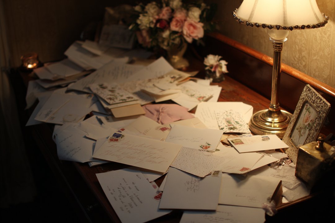 Wedding invitations on a desk | Source: Midjourney