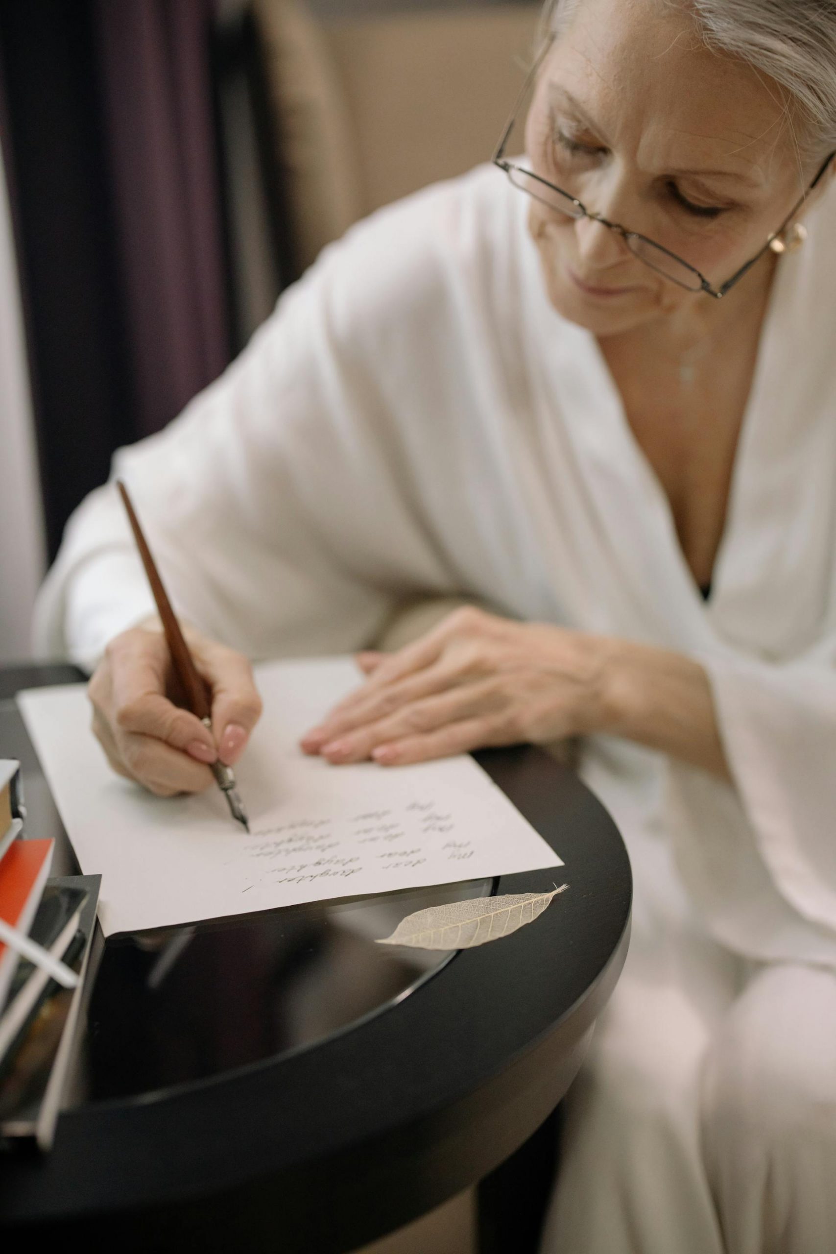 A senior woman writing on a piece of paper | Source: Pexels
