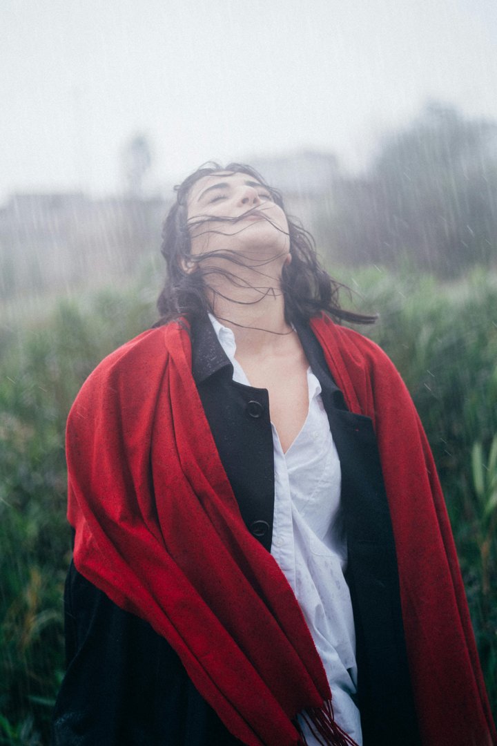Woman standing with eyes closed in the rain | Source: Pexels