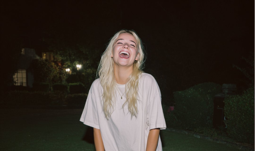 A laughing girl standing outside | Source: Midjourney