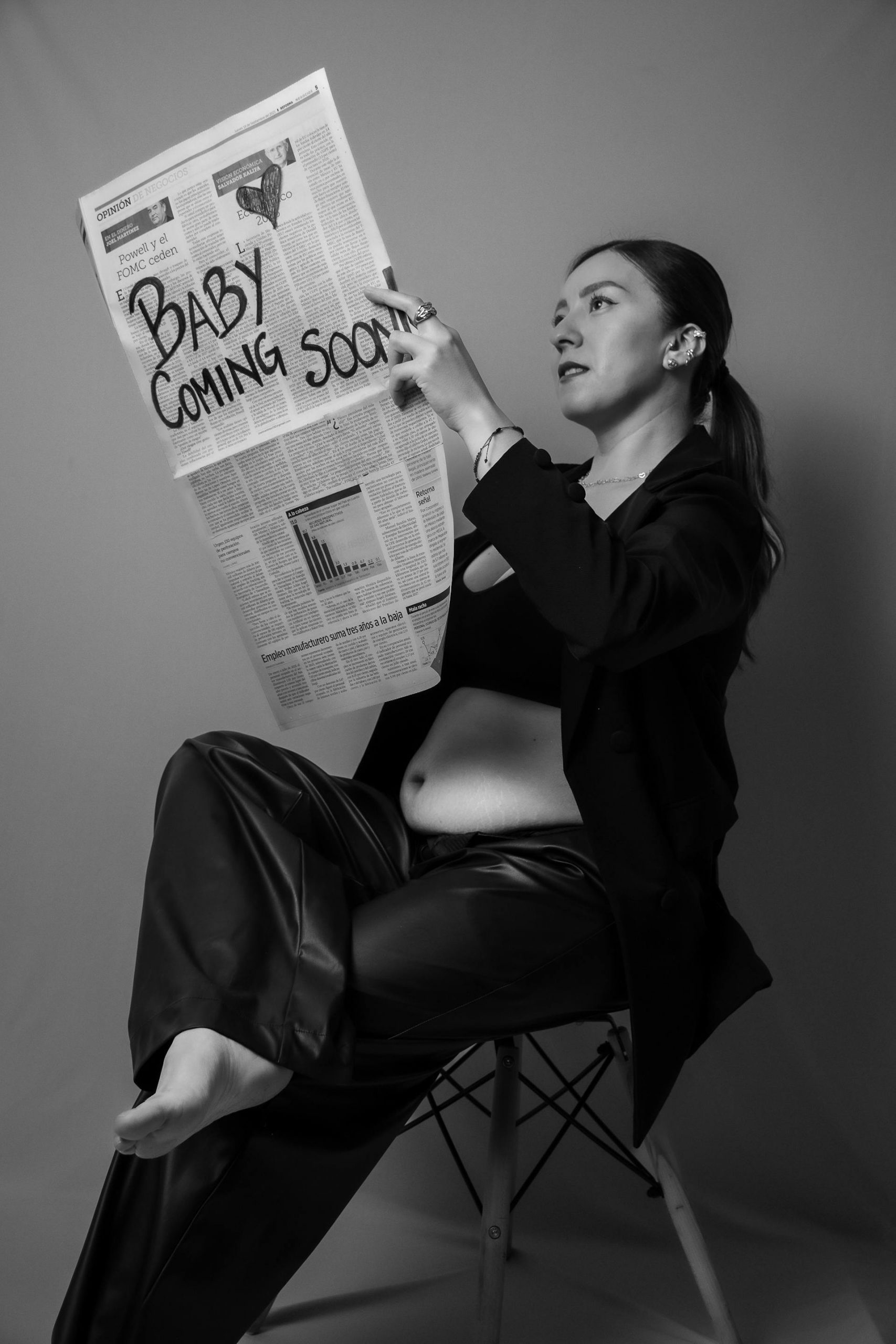 Grayscale photo of a pregnant woman holding a newspaper | Source: Pexels