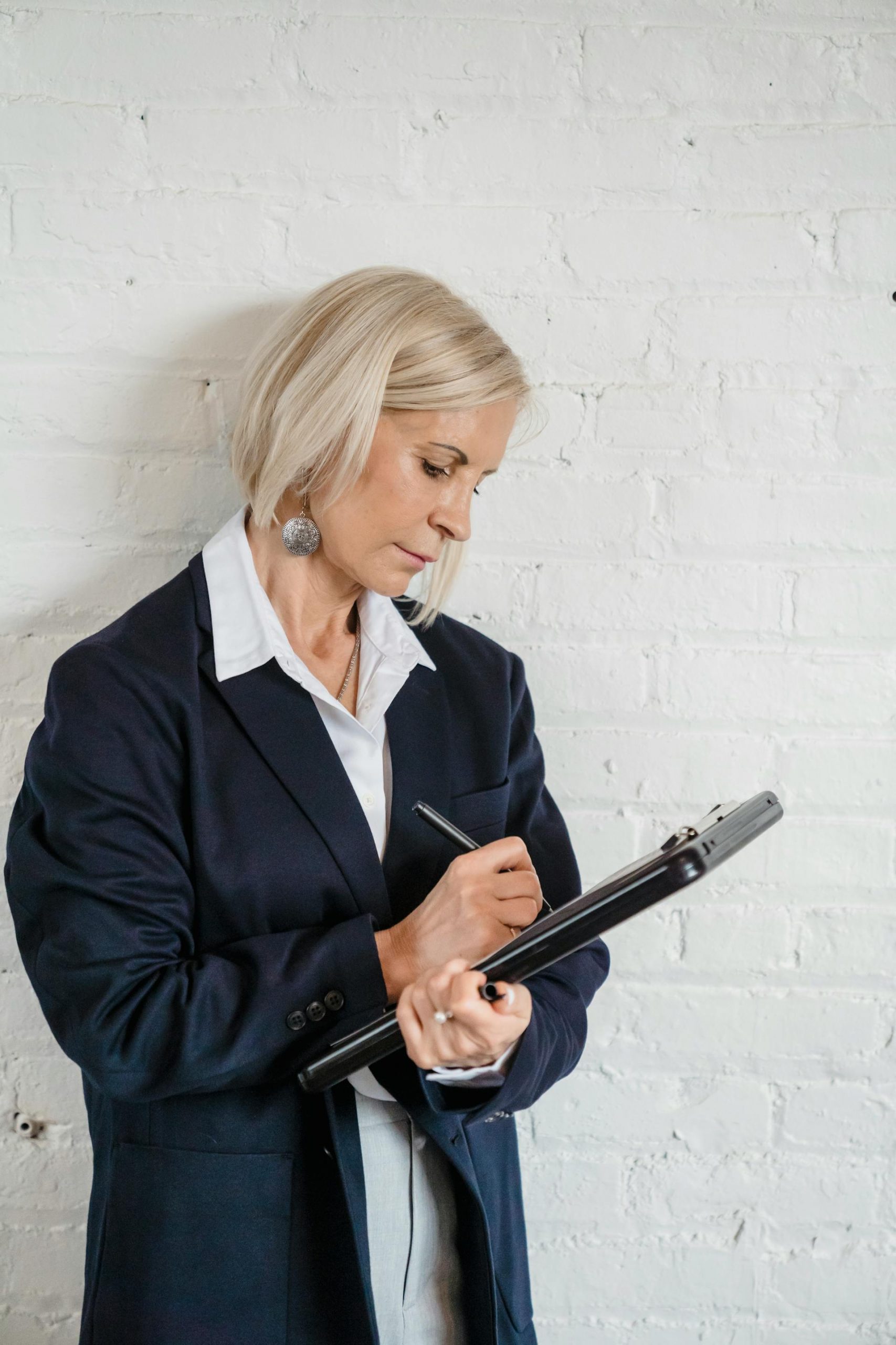 A woman making notes on a piece of paper | Source: Pexels
