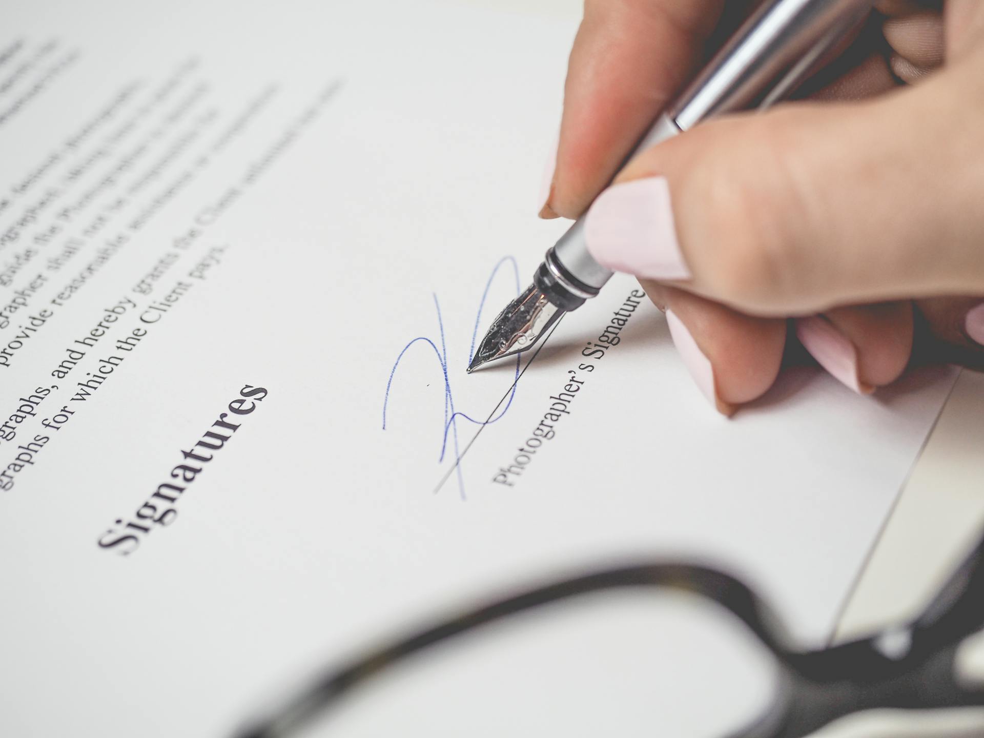 A woman signing a document | Source: Pexels