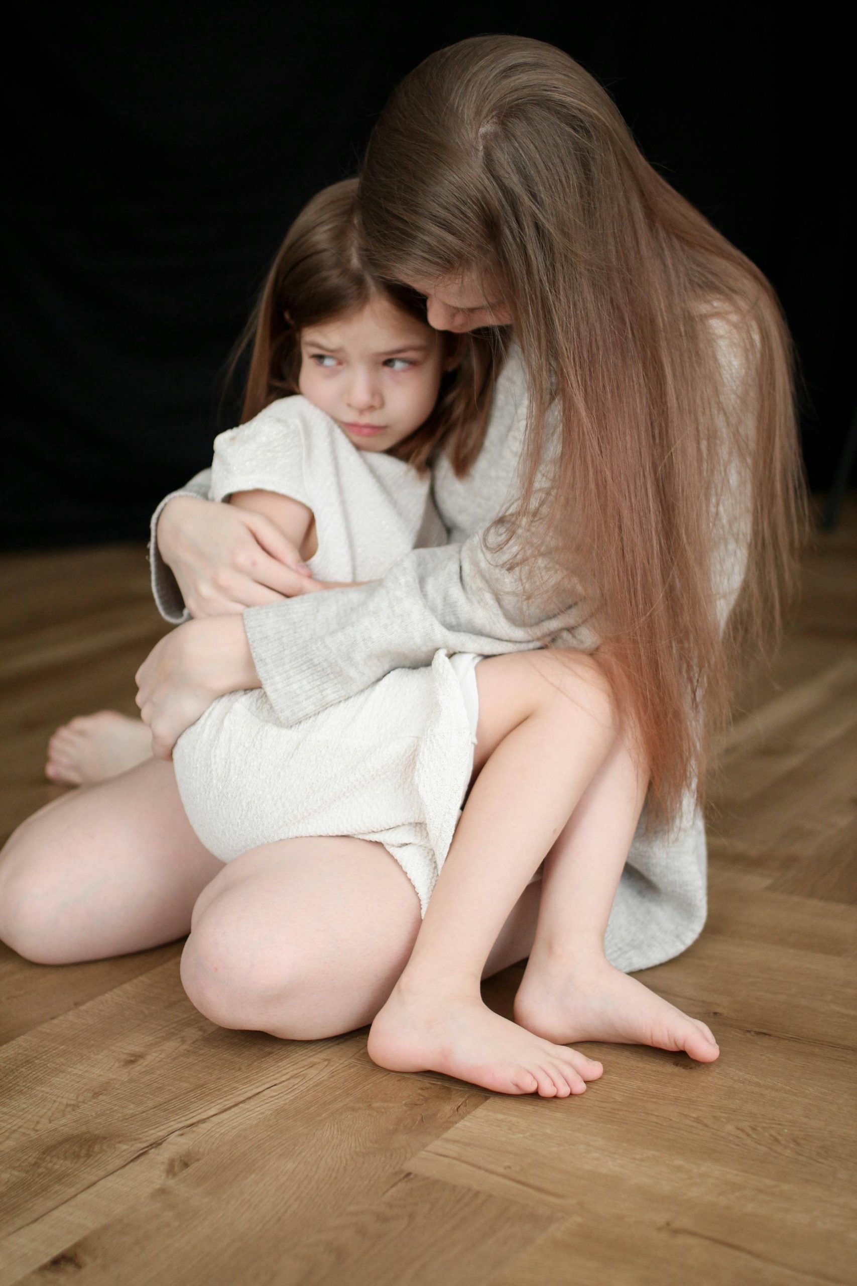A woman holding a scared little girl | Source: Pexels