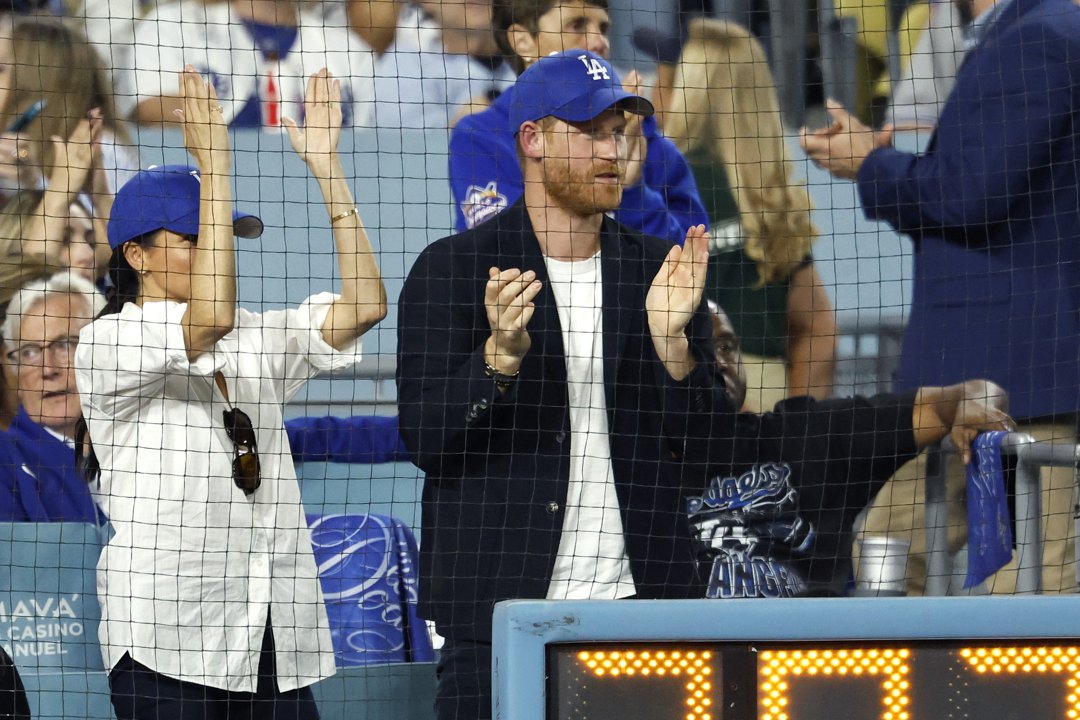 Prince Harry and Meghan Markle standing up and clapping. | Source: Getty Images