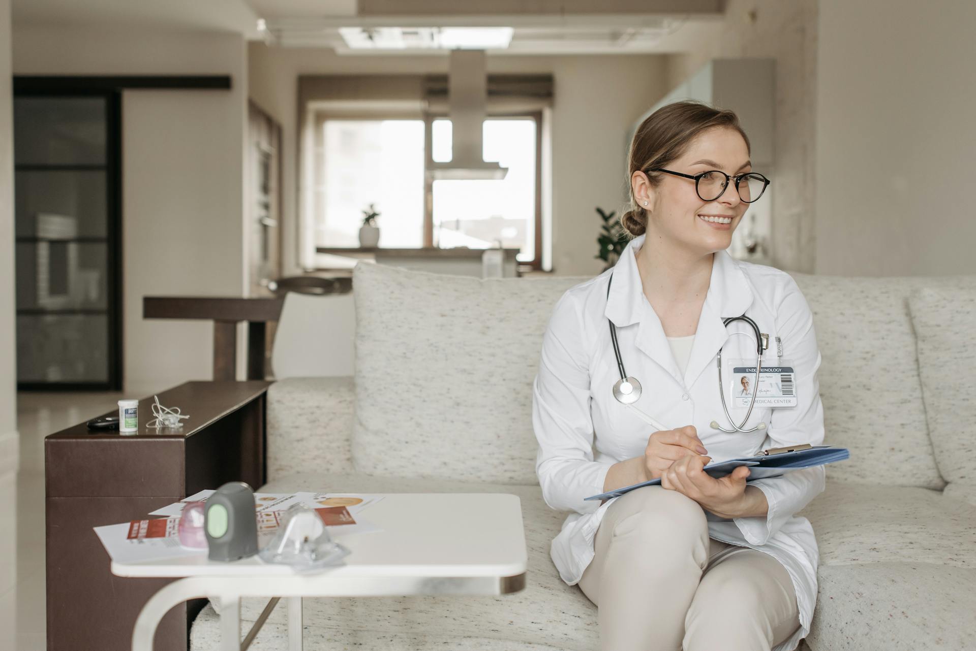 A smiling nurse sitting on a sofa | Source: Pexels