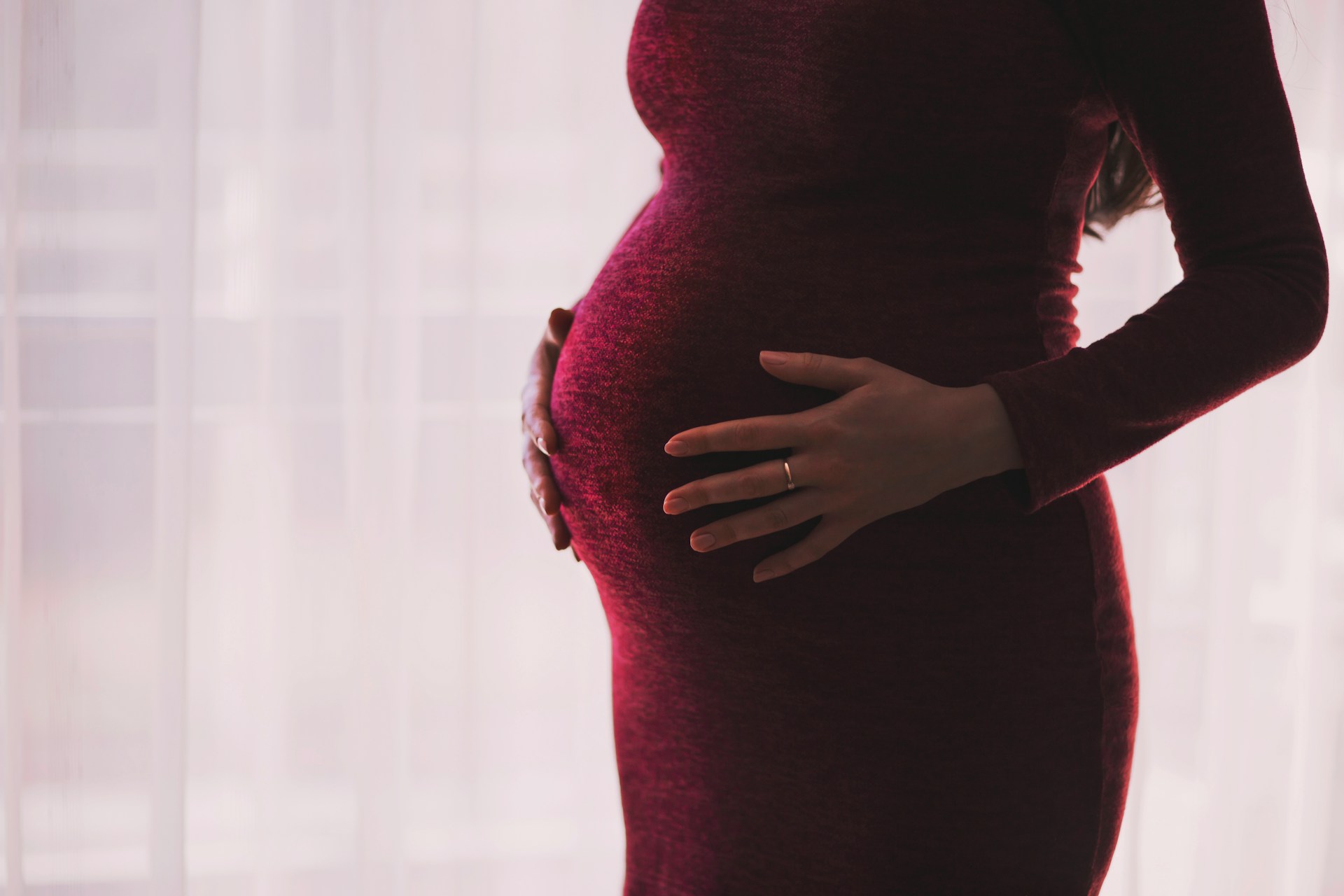 A pregnant woman holding her baby bump | Source: Unsplash