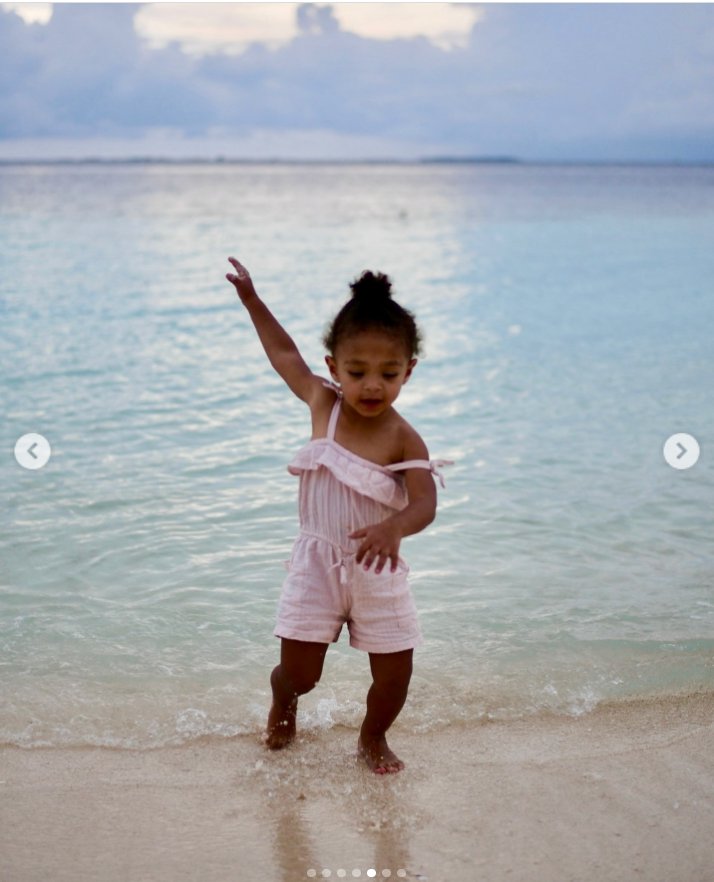 A young Olympia joyfully playing at the edge of the ocean, as seen in a post dated October 30, 2025. | Source: Instagram/serenawilliams