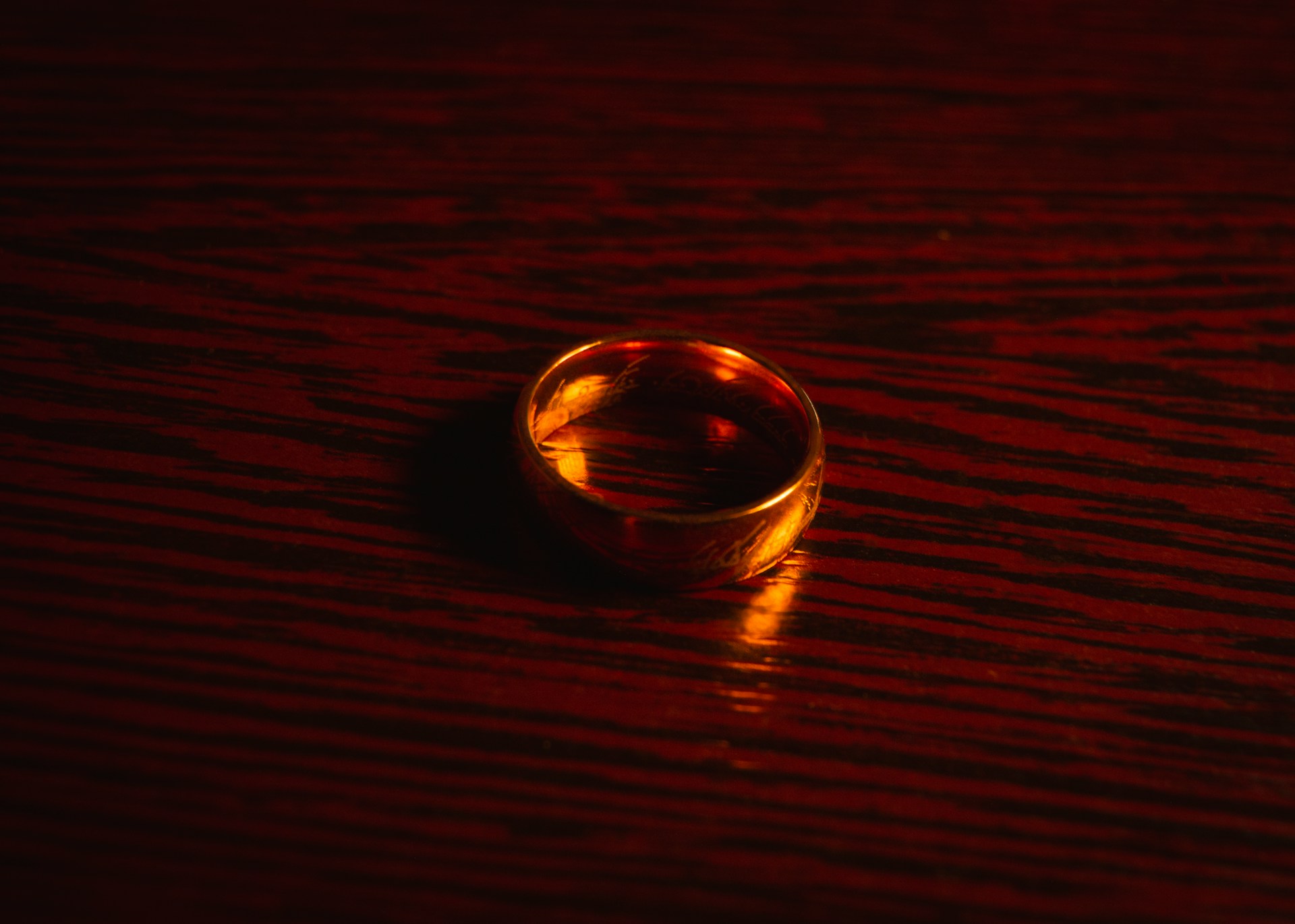 Close-up of a gold ring on a brown wooden surface | Source: Unsplash