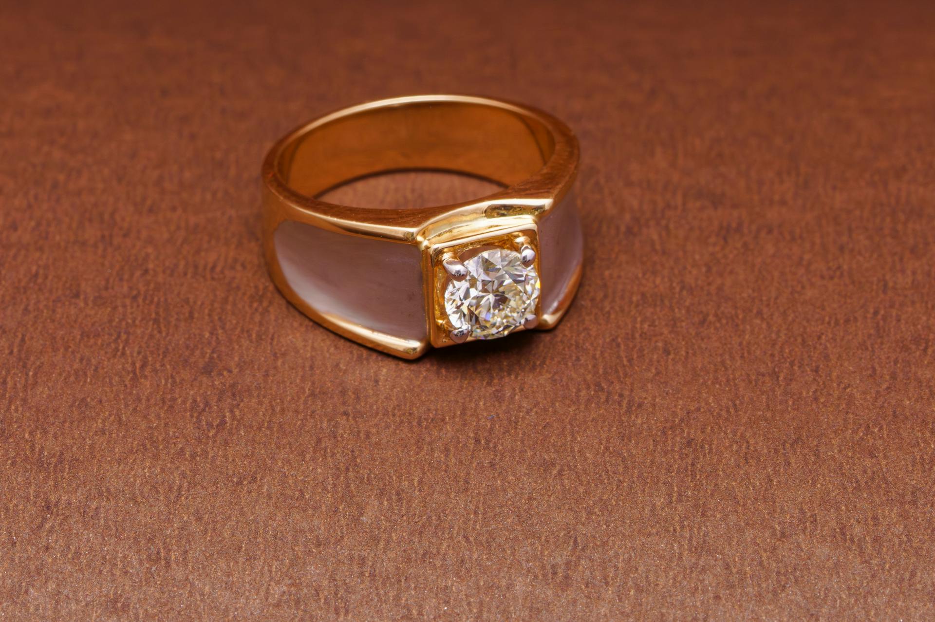 A gold ring on a brown surface | Source: Pexels
