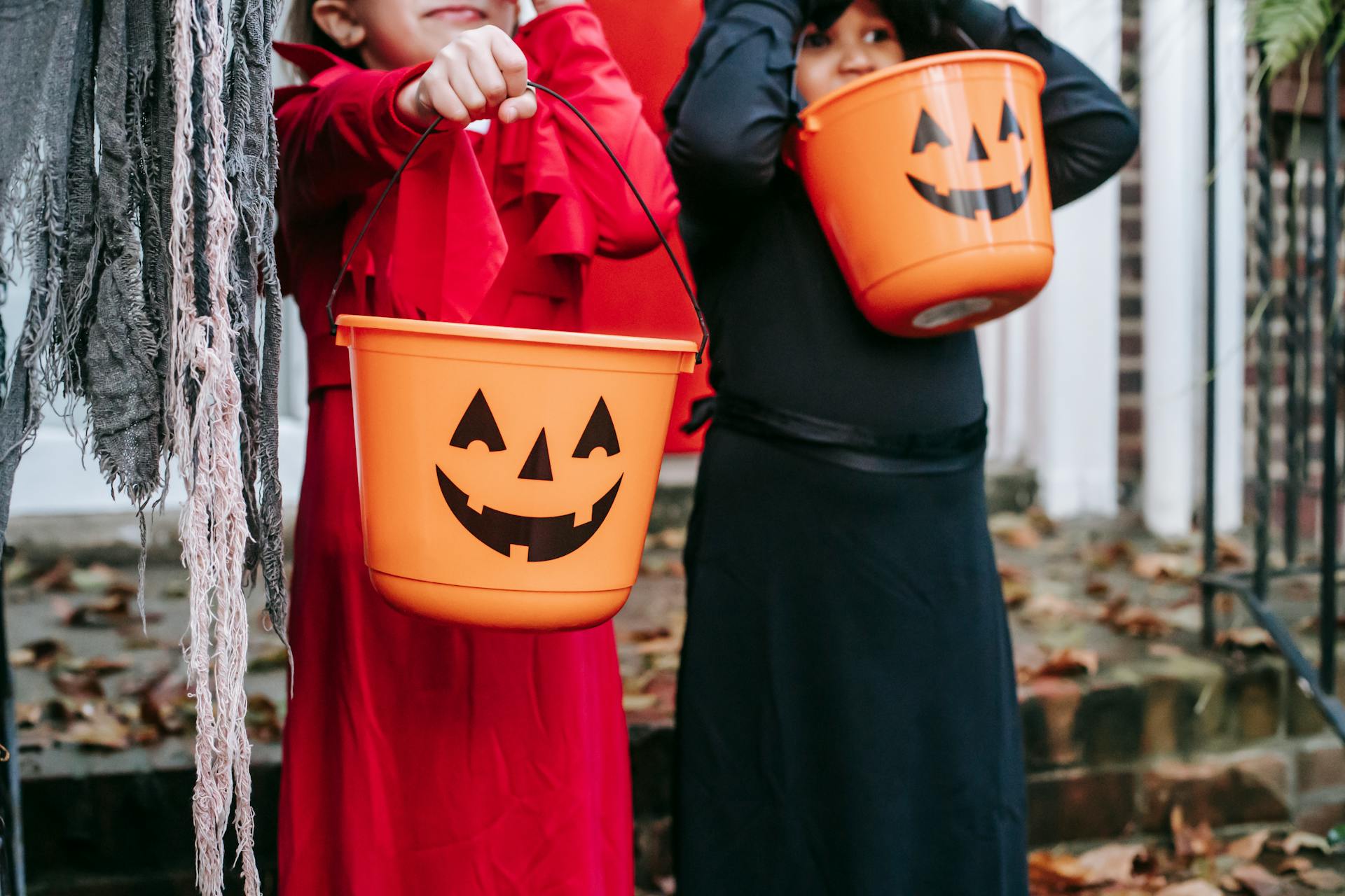 Kids holding trick-or-treat buckets | Source: Pexels