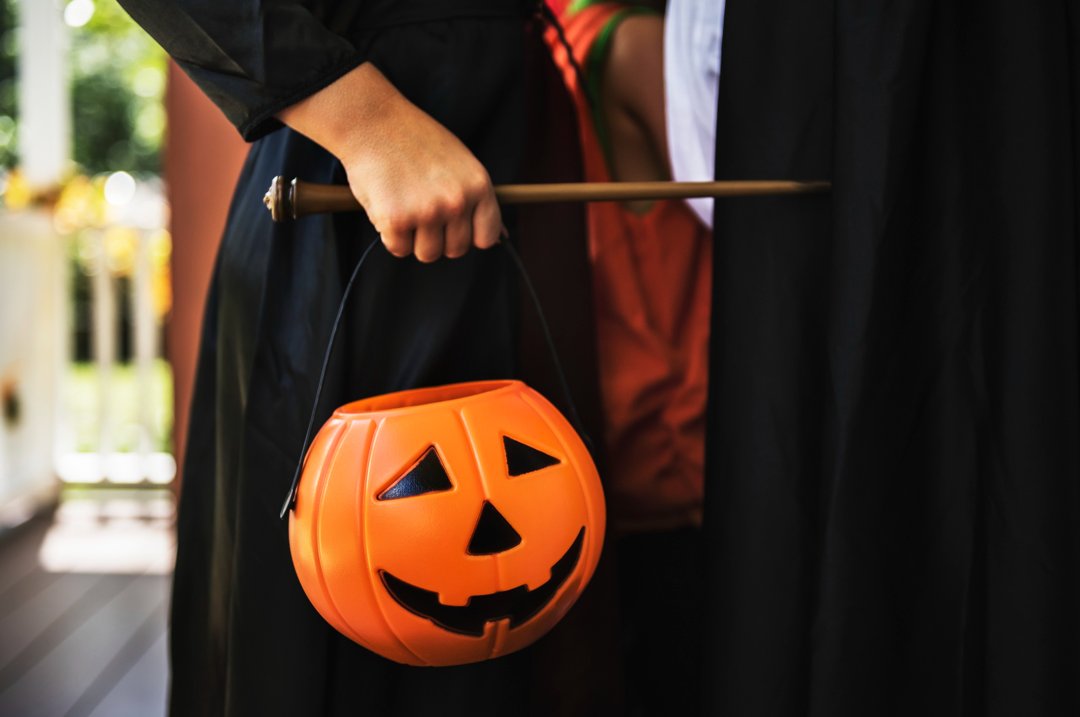 A child holding a trick-or-treat bucket | Source: Freepik