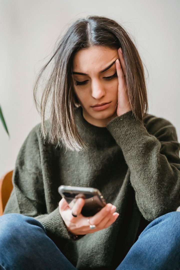 An upset woman looking at her phone | Source: Pexels