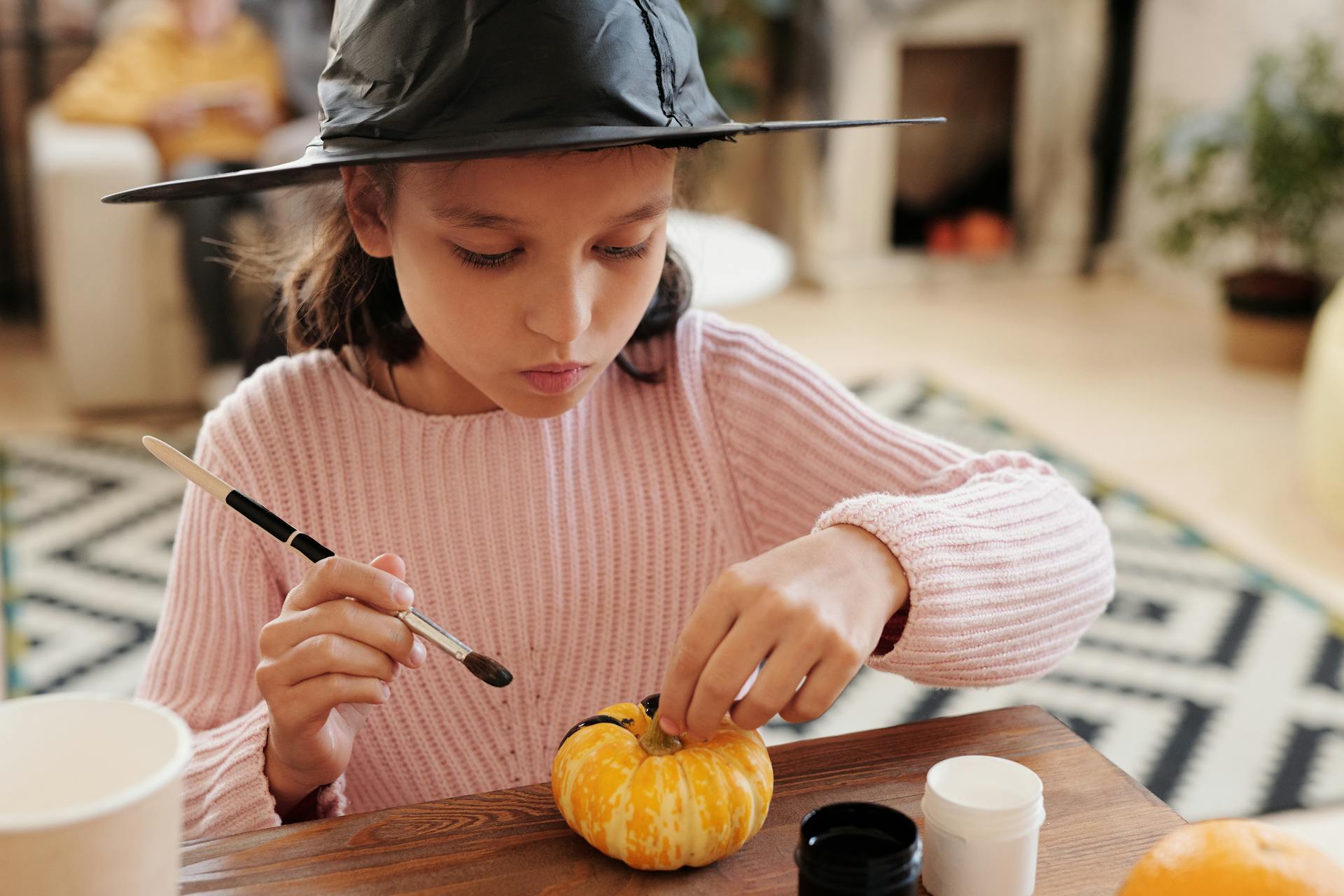A girl painting a pumpkin | Source: Pexels
