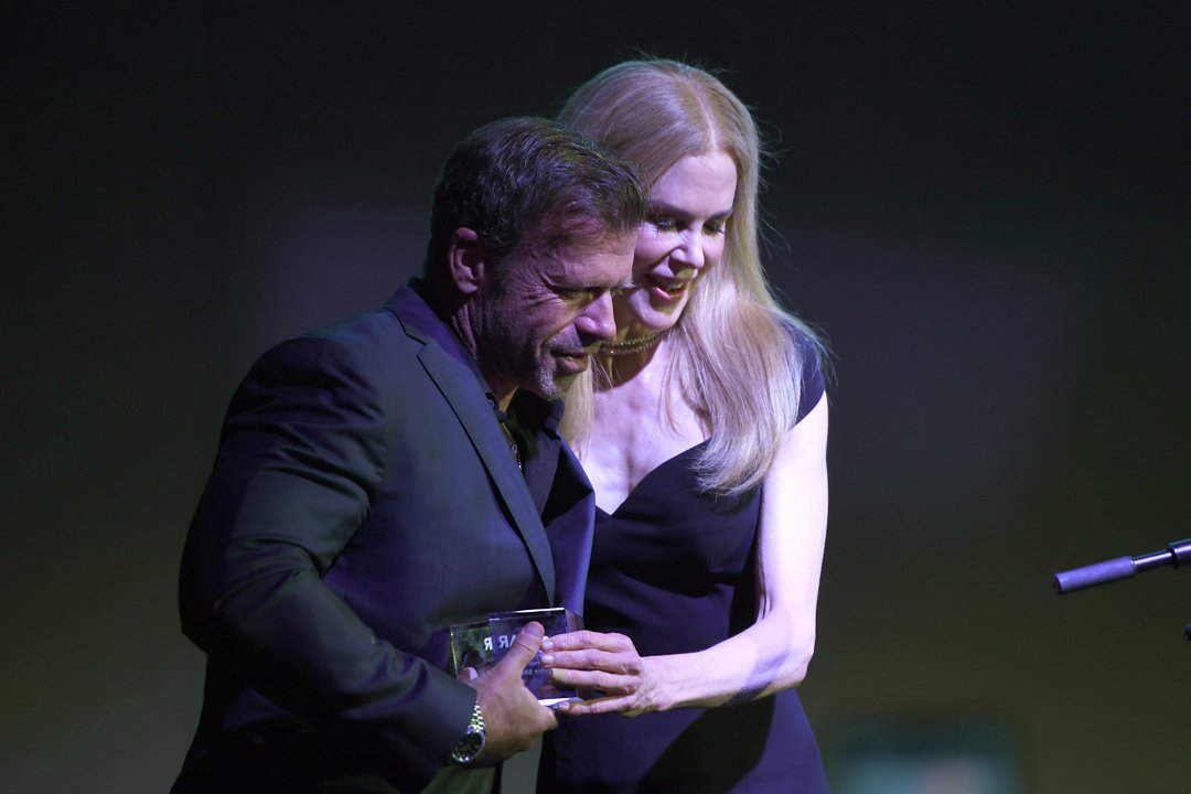 Taylor Sheridan and Nicole Kidman speaking onstage at the amfAR Gala in Dallas, Texas on October 4, 2025. | Source: Getty Images