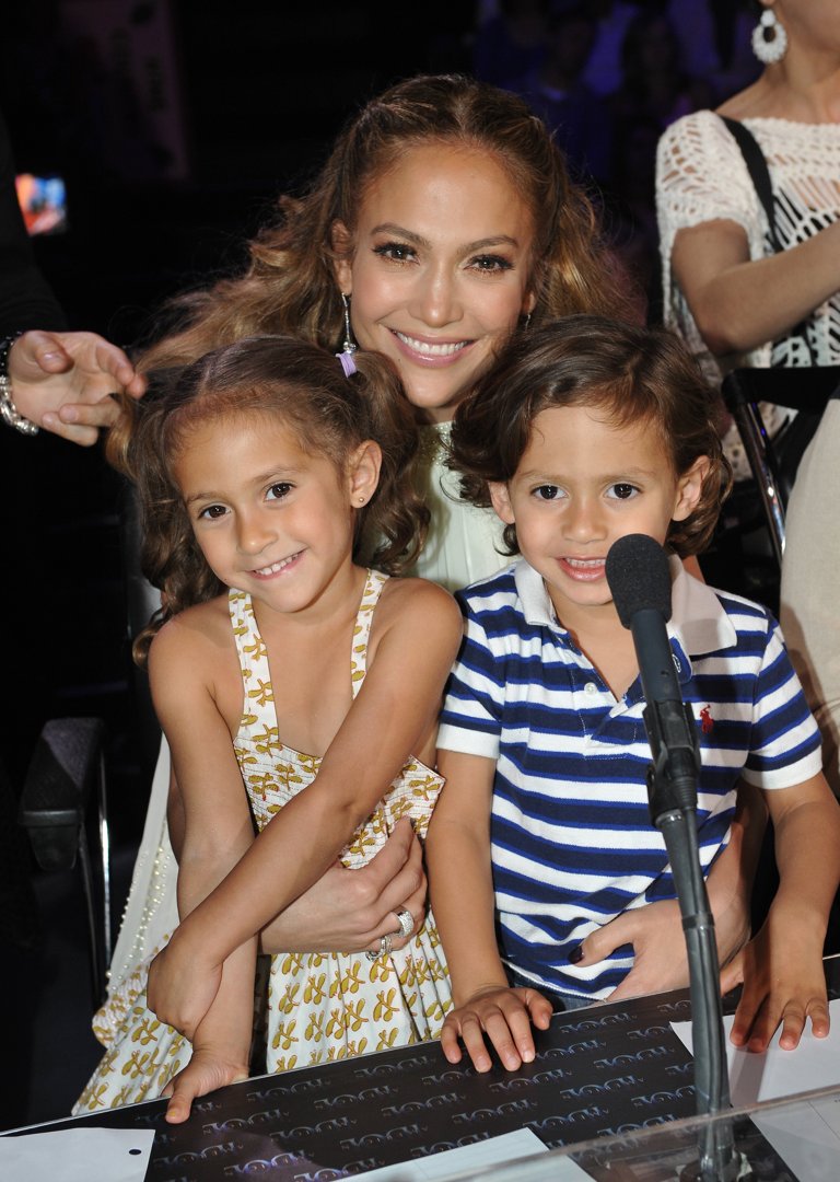 Jennifer Lopez flashes a bright smile as she poses with Emme and Max on the set of FOX’s 