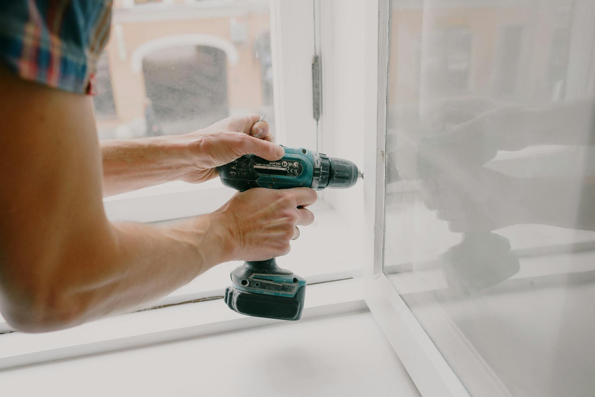 Close-up shot of a man fixing a window | Source: Pexels