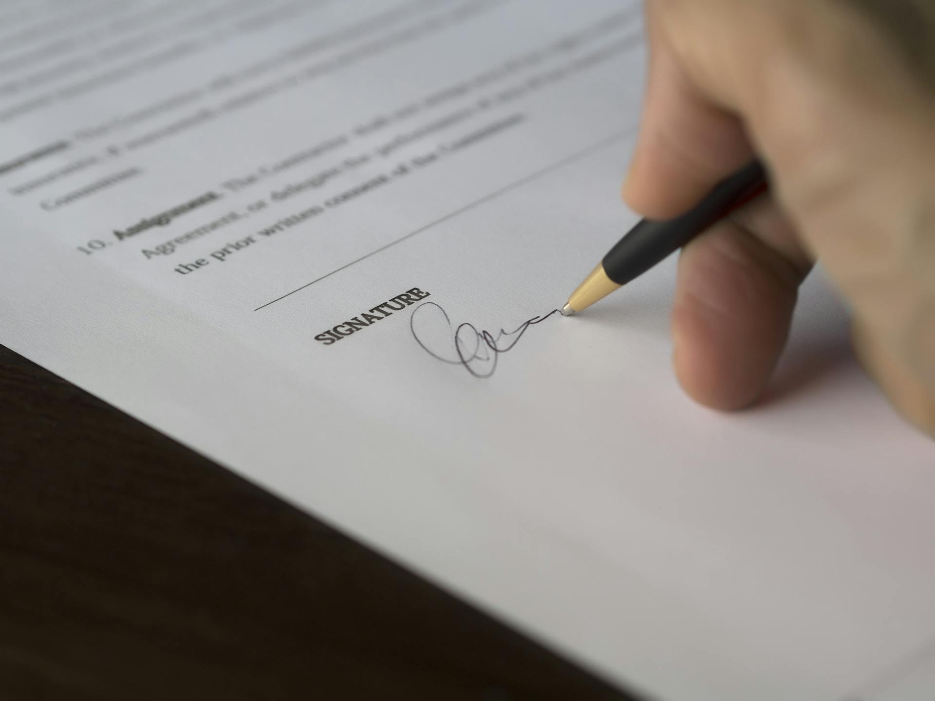 Person signing a document | Source: Pexels