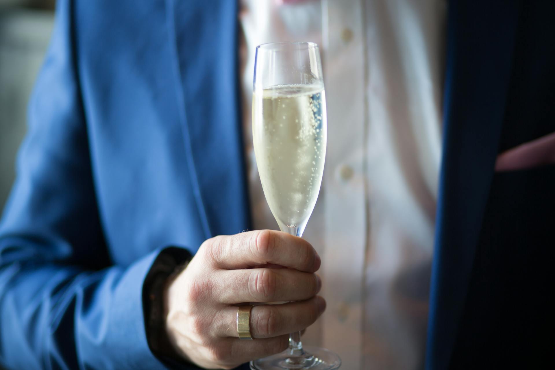 A close-up shot of a man holding a glass of champagne | Source: Pexels