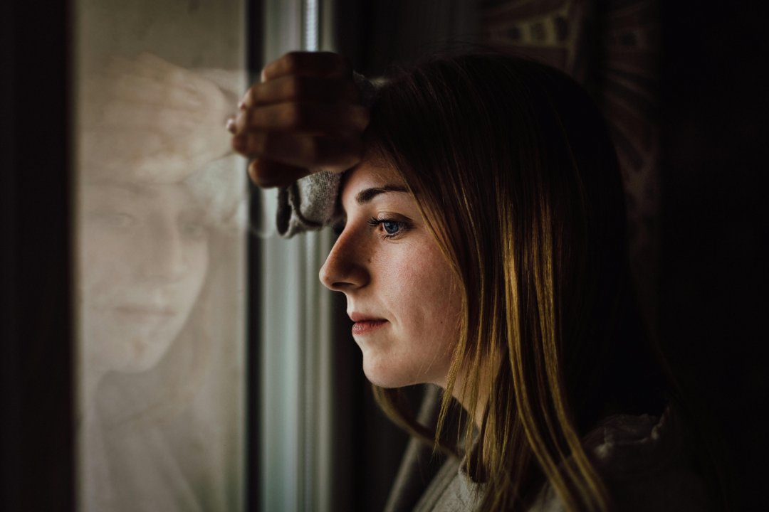 Woman leaning on a glass window | Source: Pexels