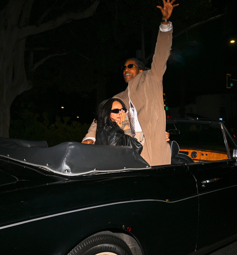 Rihanna looking on as A$AP Rocky gestures animatedly with his arm. | Source: Getty Images