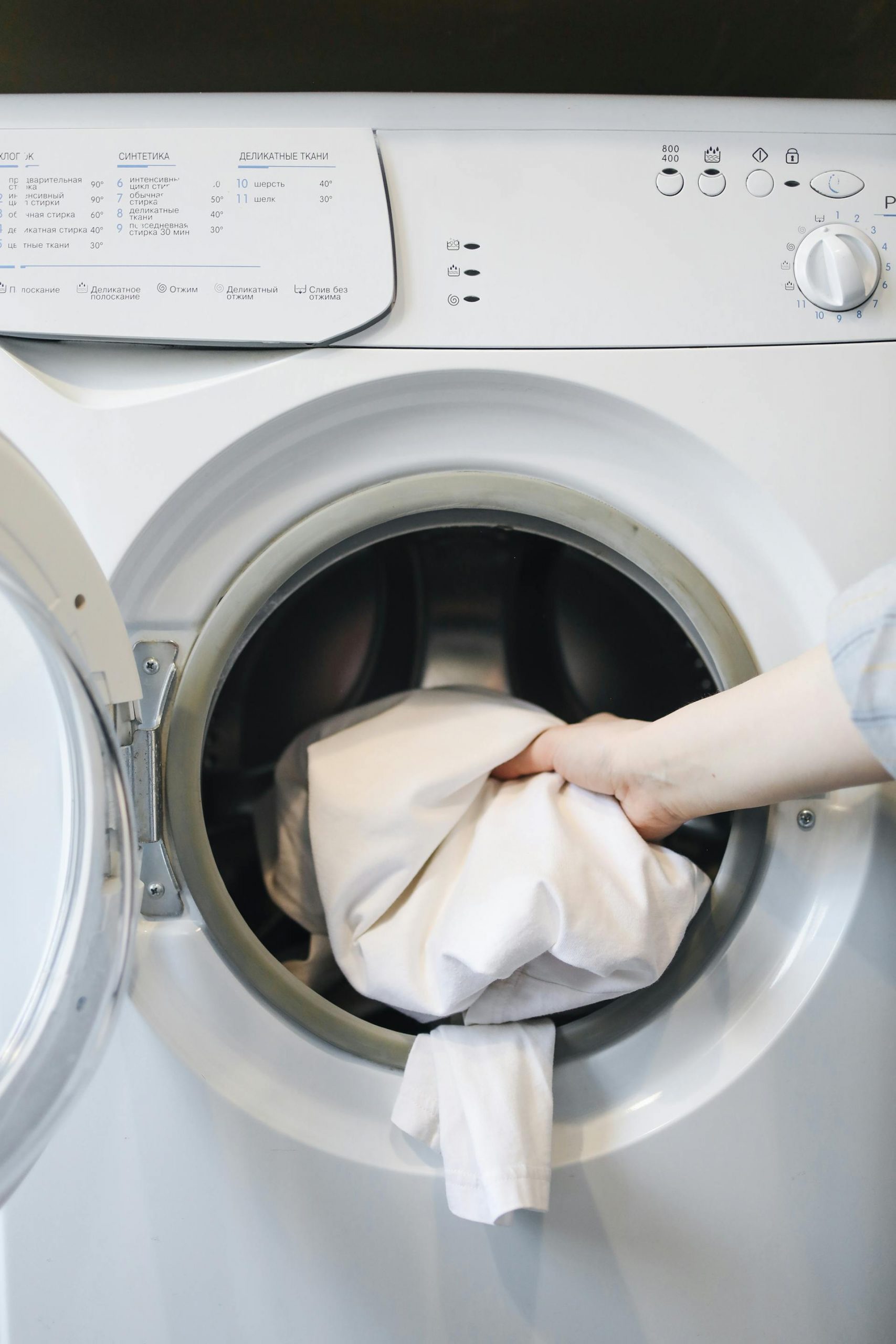 A person putting clothes in a washing machine | Source: Pexels