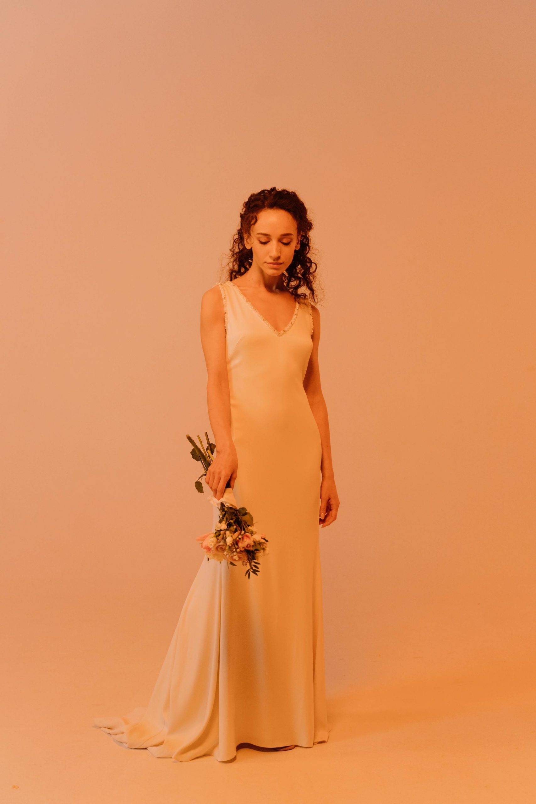 A woman facing down while holding a bouquet | Source: Pexels