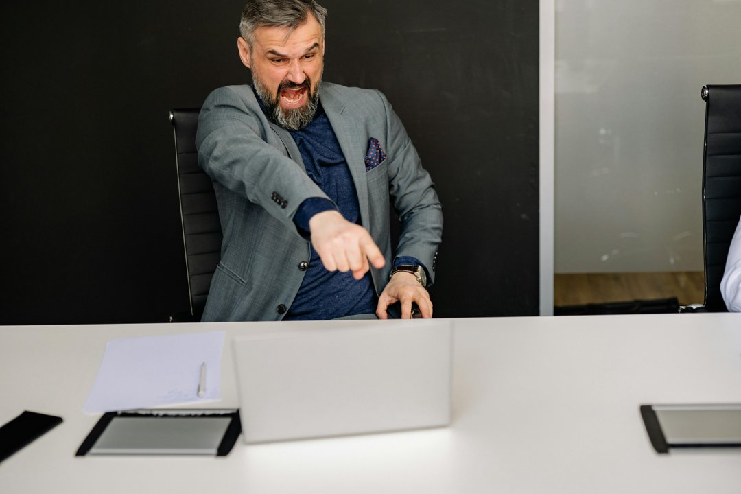 An angry businessman pointing at his laptop's screen | Source: Pexels