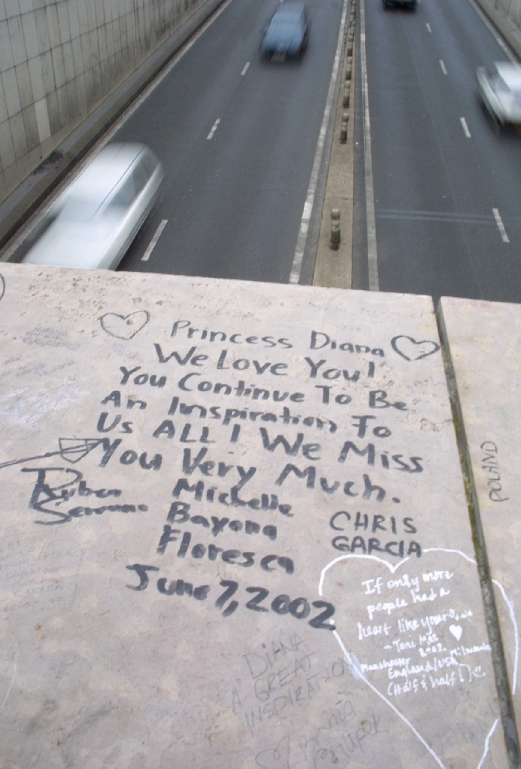 A fan pays tribute to the late Princess Diana of Wales with a note left near the crash site on the fifth anniversary of her death on August 30, 2002 in Paris, France | Source: Getty Images