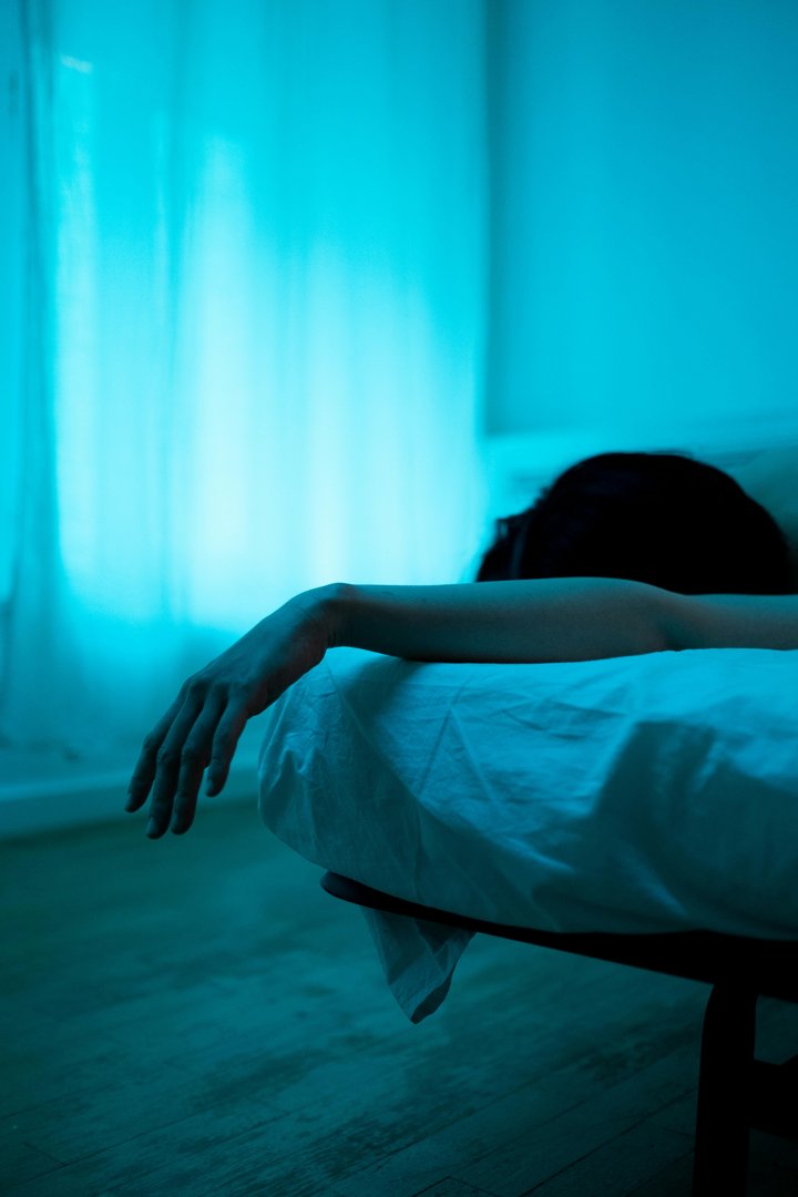 A woman lying in bed in the dark | Source: Pexels