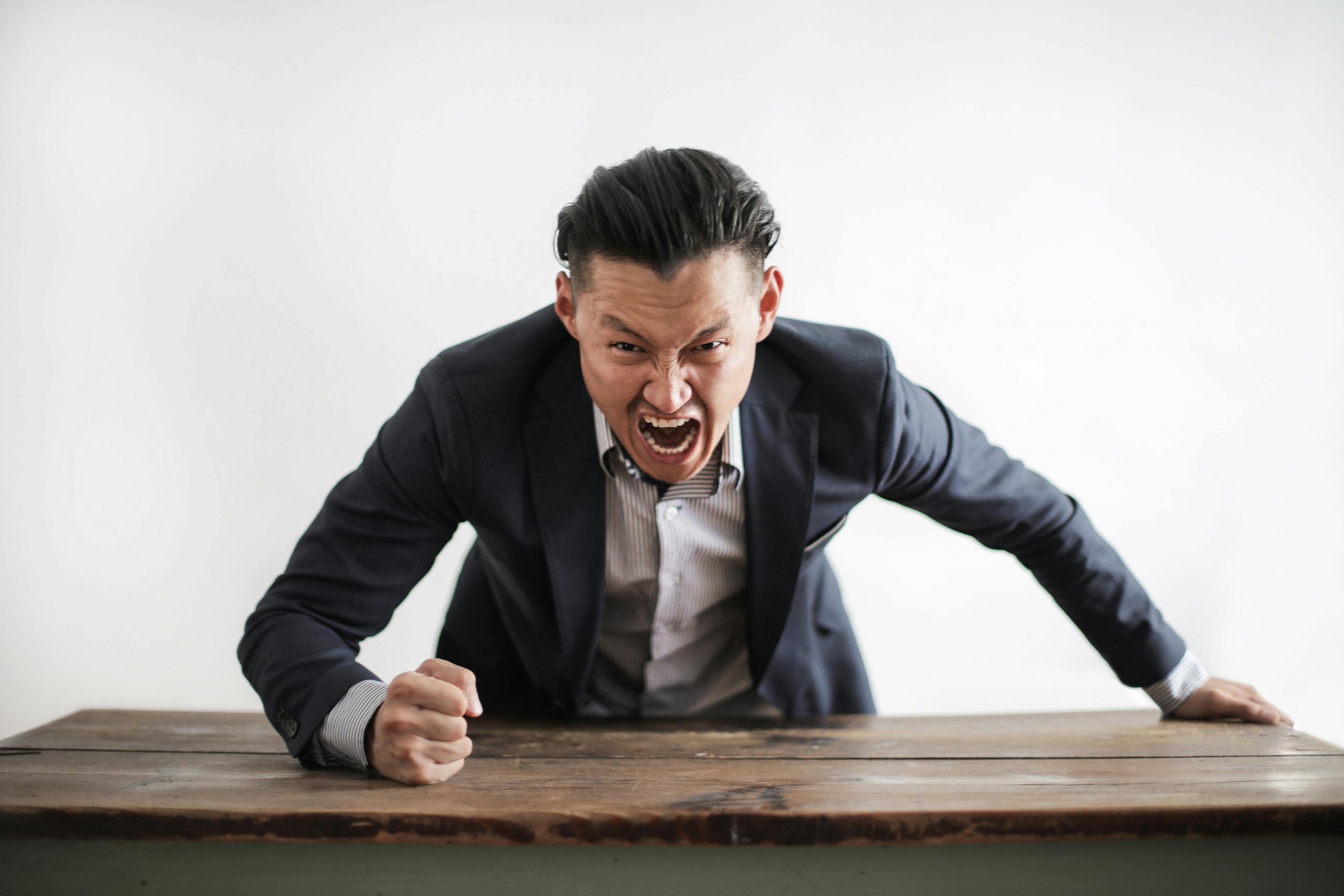 An angry man slamming his fist on a table | Source: Pexels