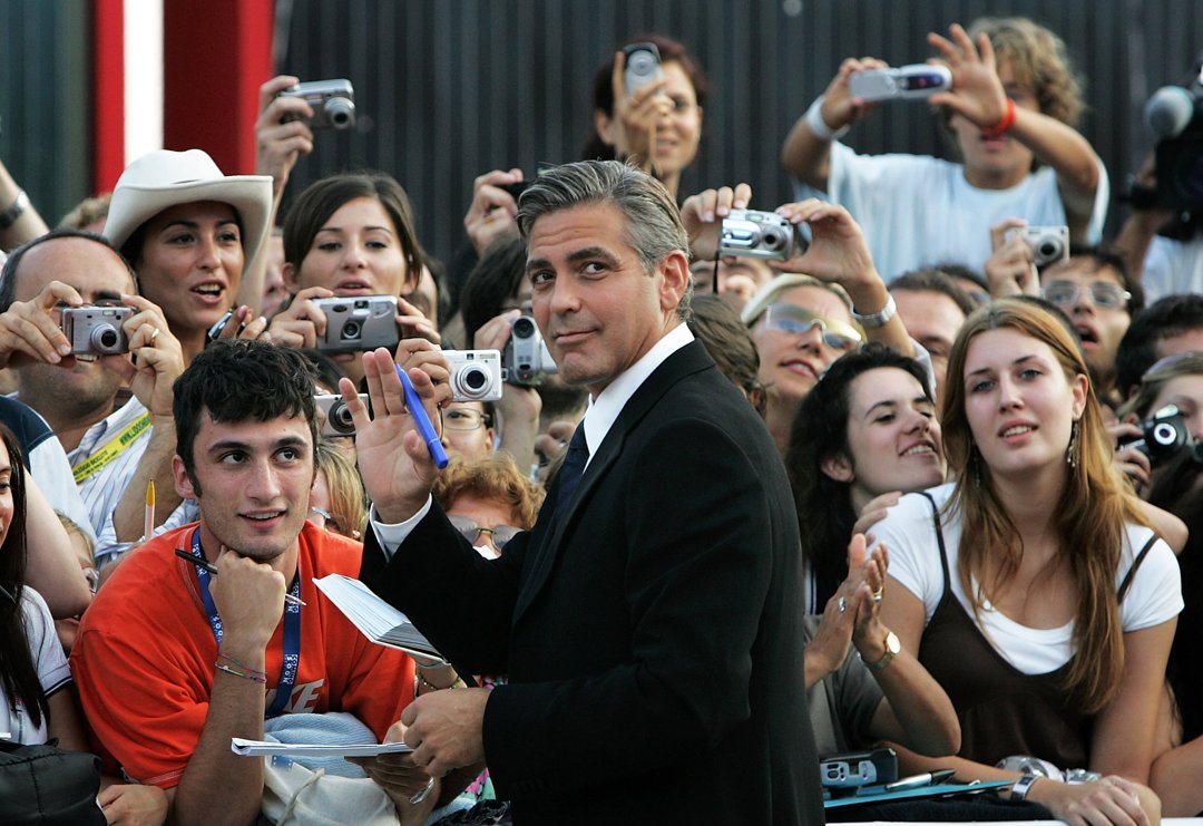 George Clooney signs autographs as he arrives for the Golden Lion Awards at the Palazzo del Cinema in Venice, Italy on September 10, 2005 | Source: Getty Images