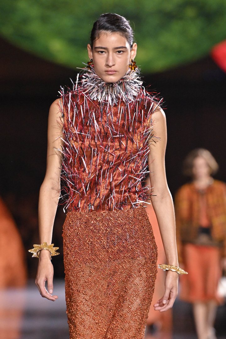 A model walks the runway during the Chanel Ready-to-Wear Spring/Summer 2026 show at Paris Fashion Week in France. She wears a brown dress with a classic skirt, while the upper part is reimagined with striking, spike-like details.
