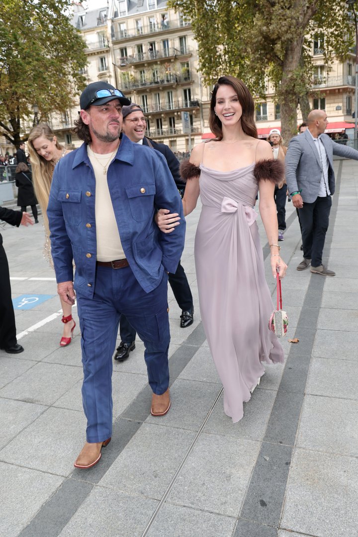 Lana Del Rey, who was wearing a bright smile, strolled with Jeremy Dufrene, who kept his look relaxed in a matching blue jacket and pants set paired with an off-white T-shirt. He completed the outfit with a black hat, sunglasses, and brown shoes.