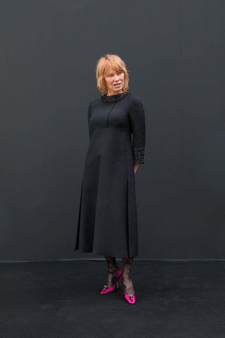 Pamela Anderson attended the Valentino show at Paris Fashion Week in France, exuding sophistication in a black boat-neck midi dress with a sequined collar and cuffs. She paired the look with patterned sheer tights and bright pink satin heels adorned with a sparkling brooch.