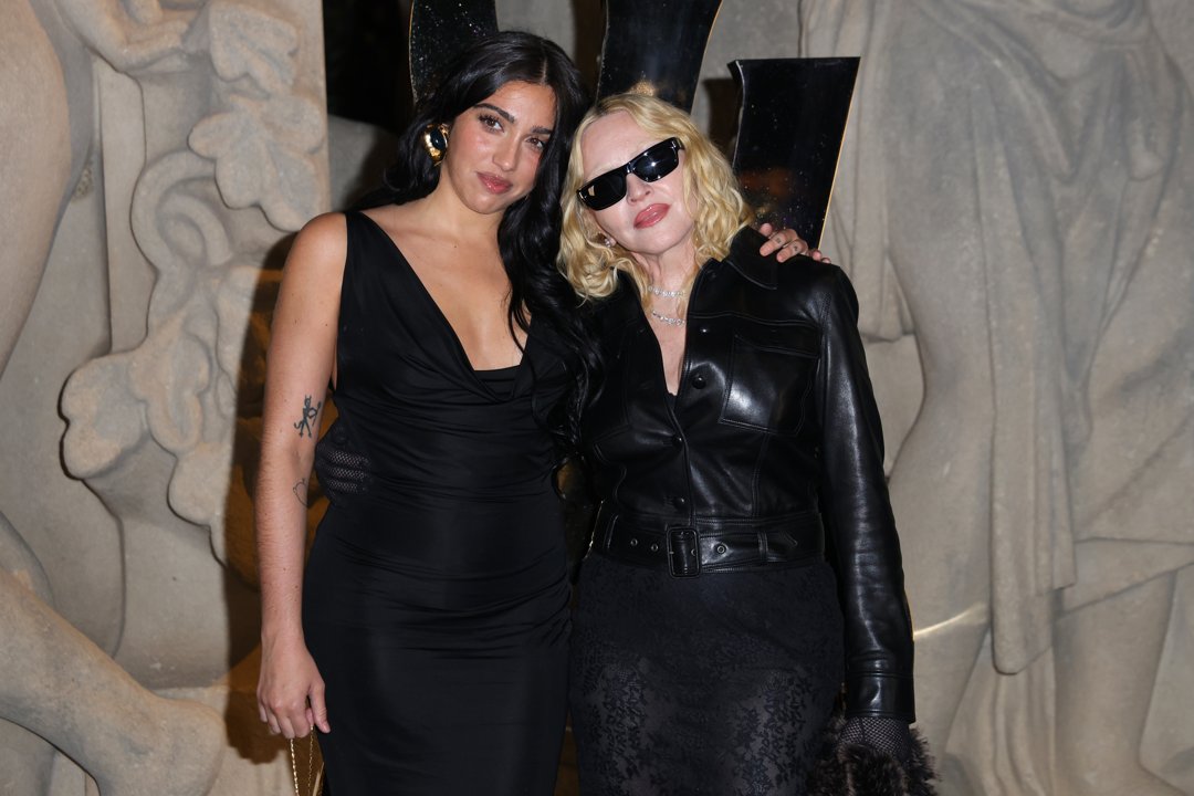 Lourdes Leon and Madonna attended the Saint Laurent Spring/Summer 2026 show at Paris Fashion Week, held at Fontaine du Trocadéro in France. Madonna wore a belted black leather button-down top with a sheer skirt and black tights, accessorized with diamond-encrusted chains. Leon opted for a black halter midi dress. She completed her look with sheer black tights.