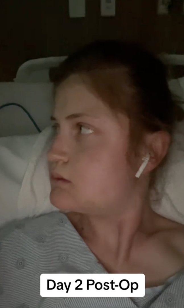 Wearing a hospital gown and AirPod, Virginia Elder gazes sideways during her second day of healing. | Source: TikTok/virginiaeelder