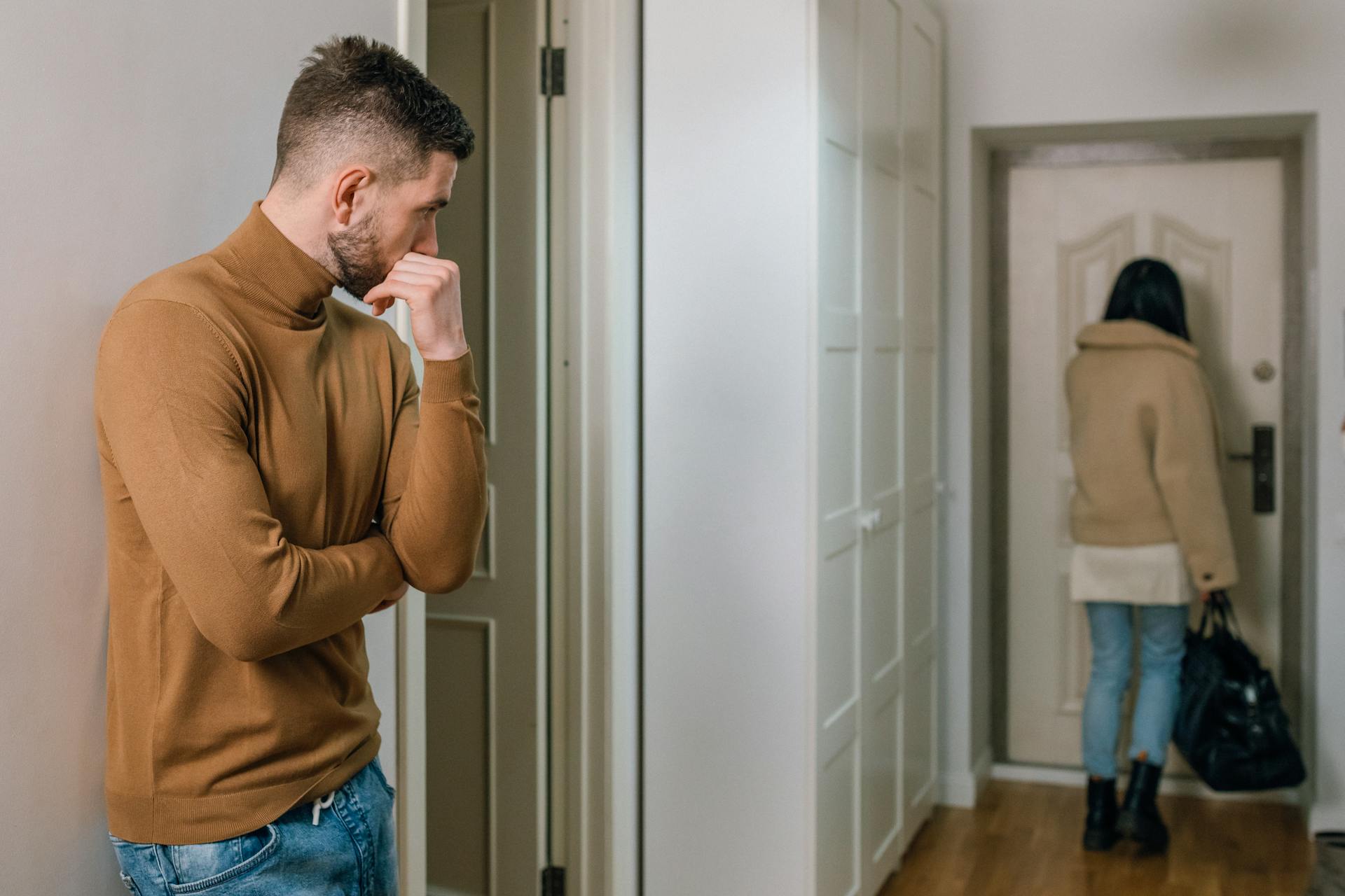 Man watching a woman walk out the door | Source: Pexels