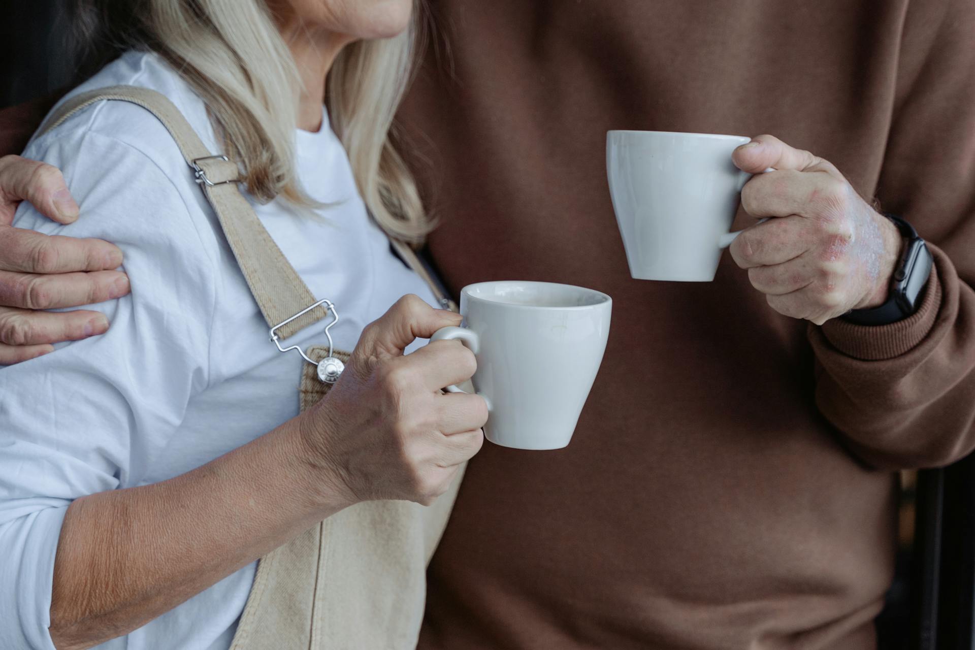 A couple holding white mugs | Source: Pexels