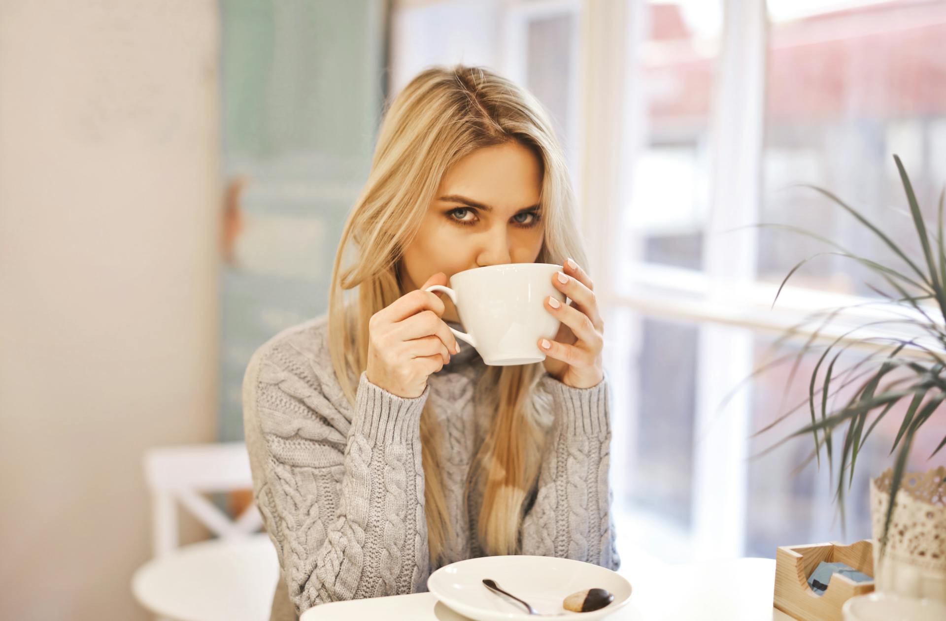 A suspicious woman drinking from mug | Source: Pexels