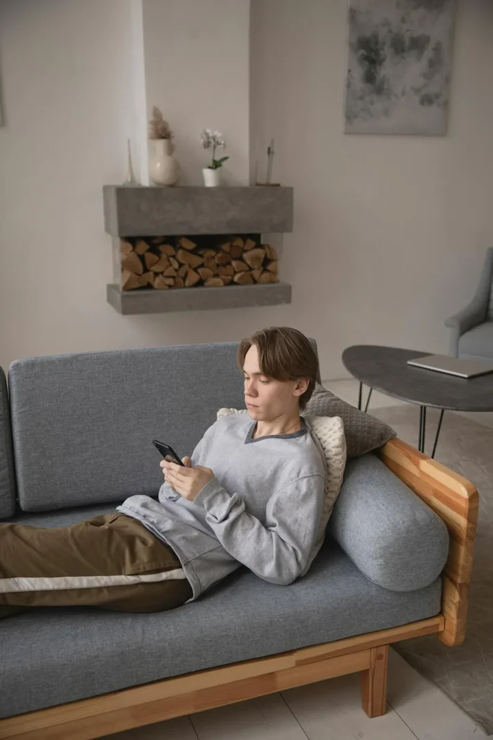 A man on his phone in his living room | Source: Pexels